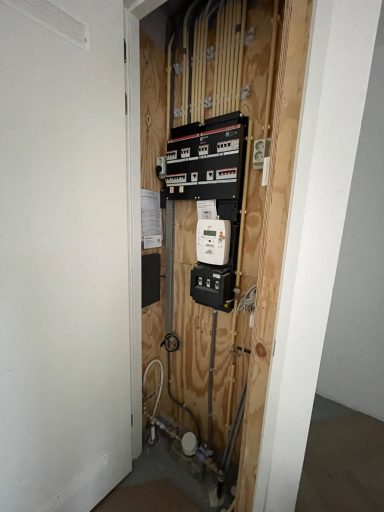 Stopcontactpaneel en elektriciteitsmeters in een houten wandklap.